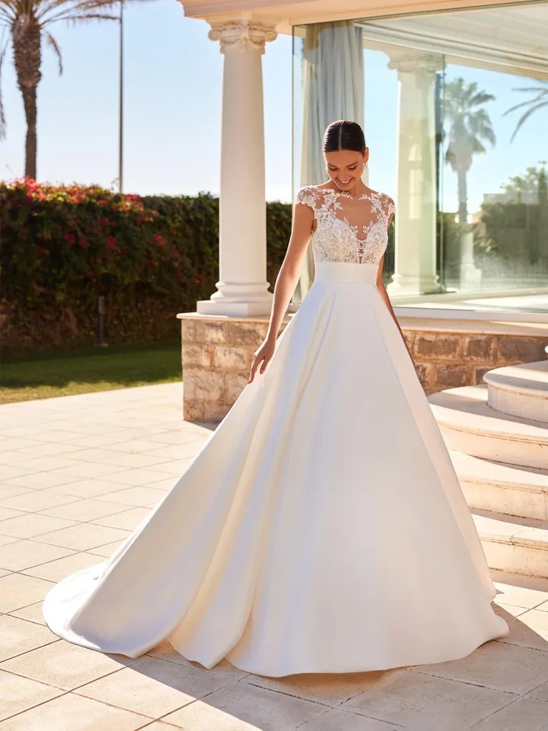 Obrázek ženy se svatebními šaty April z kolekce House of St. Patrick od Pronovias Group